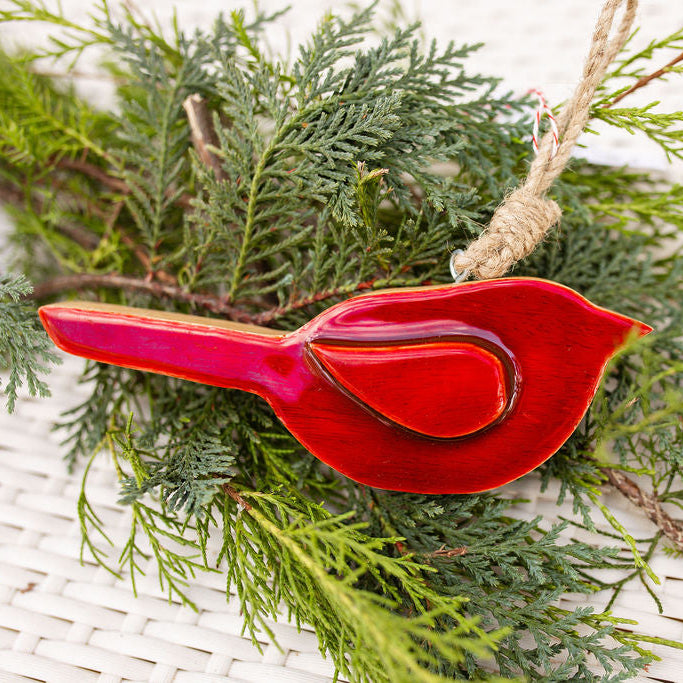 Red cardinal bird ornament on a branch with greenery