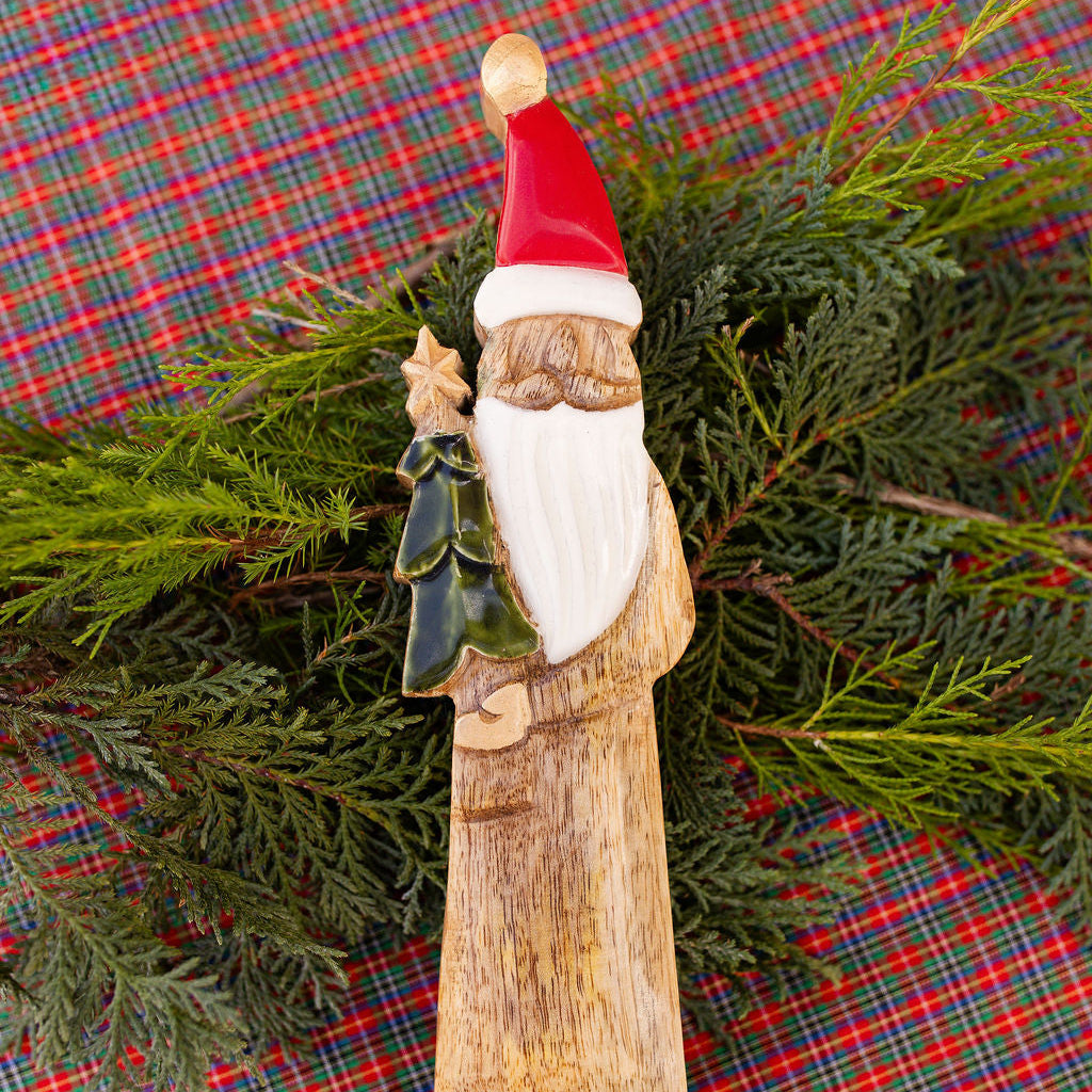 Wooden Santa Claus figure on a plaid fabric background